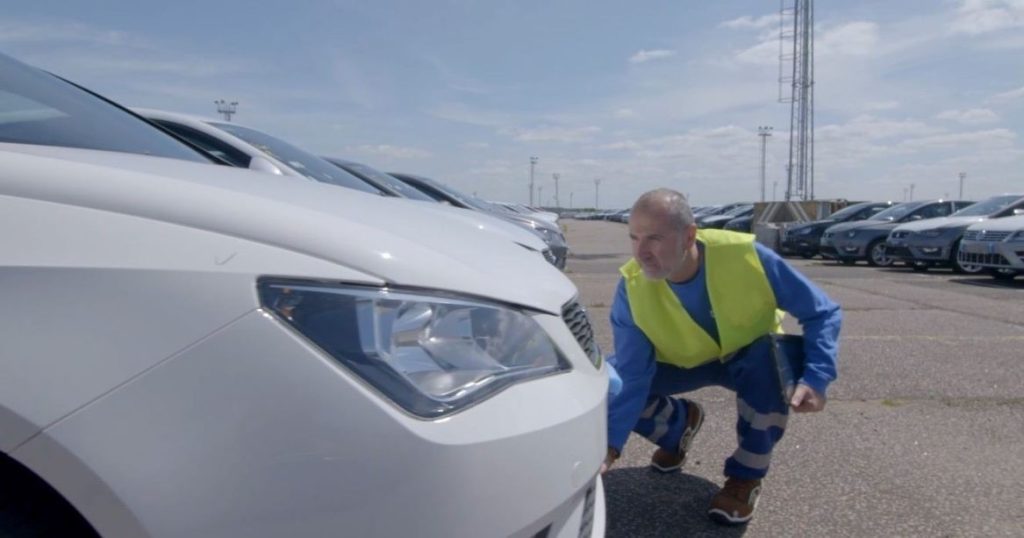 Inspector performing a vehicle check for an accurate damage report